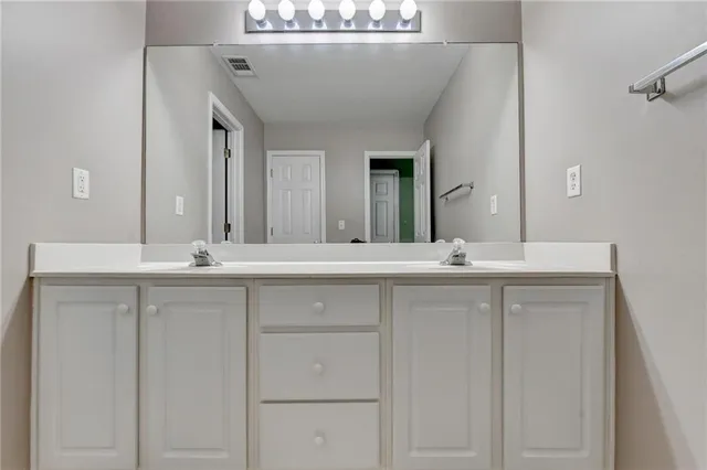 a bathroom with a double vanity sink and a mirror