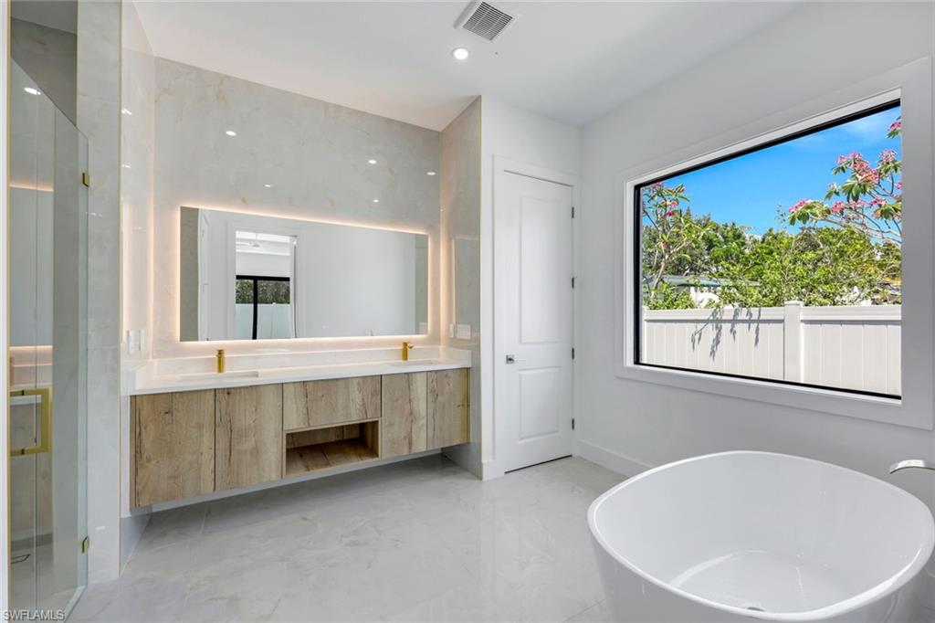 1312 Trail Terrace Drive Naples, FL 34103 - Photo 14 of 33 a bathroom with a double vanity sink and a bathtub