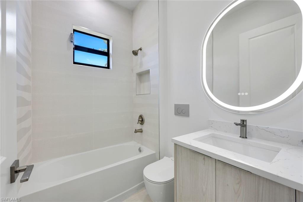 1312 Trail Terrace Drive Naples, FL 34103 - Photo 18 of 33 a bathroom with a sink a toilet and a mirror