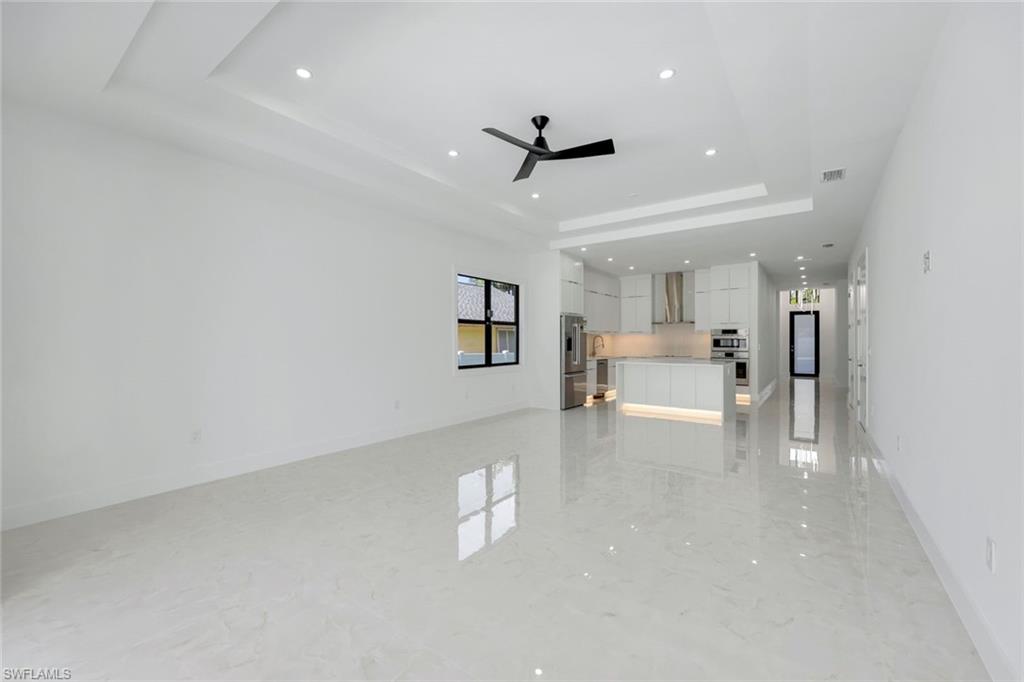 1312 Trail Terrace Drive Naples, FL 34103 - Photo 4 of 33 wooden floor in an empty room with a kitchen