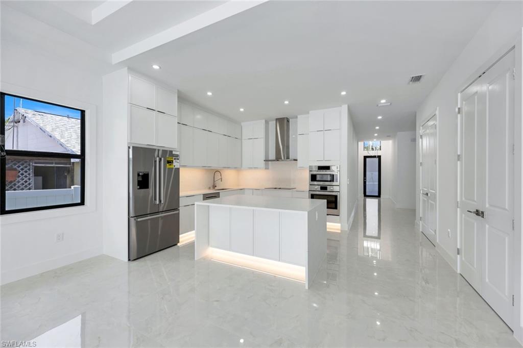 1312 Trail Terrace Drive Naples, FL 34103 - Photo 10 of 33 a large kitchen with stainless steel appliances kitchen island a large counter top and a refrigerator