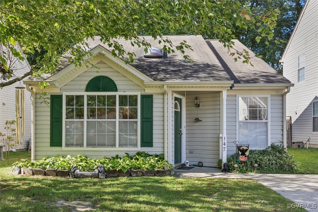 a front view of a house with a garden and plants