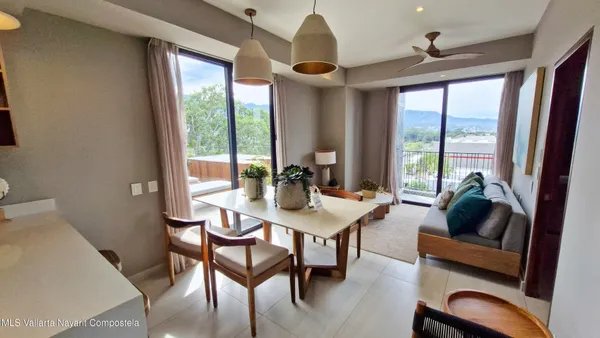 a kitchen with a refrigerator a stove and a dining table with wooden floor