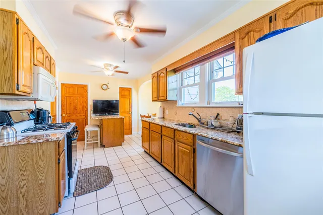 a large kitchen with stainless steel appliances a stove a sink dishwasher and a refrigerator