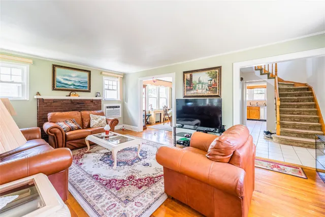 a living room with furniture a flat screen tv and a window