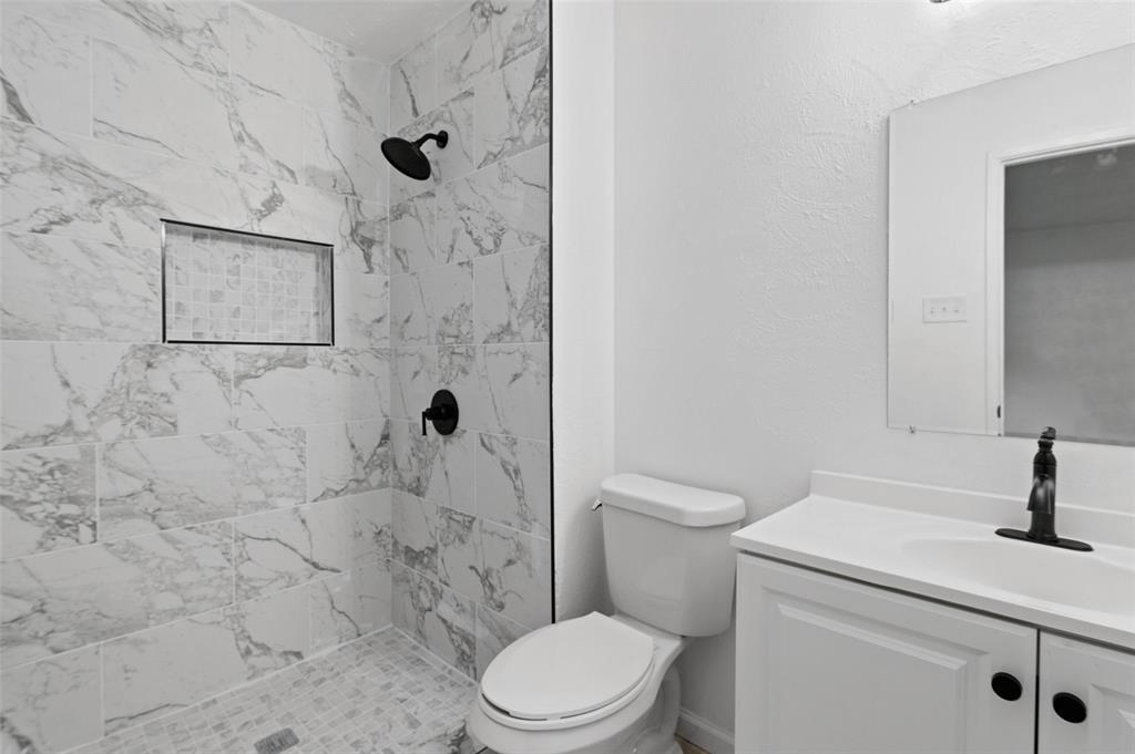 2068 East Peters Colony Road Carrollton, TX 75007 - Photo 17 of 24 a bathroom with a toilet sink and shower