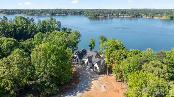 an aerial view of a house with a yard and lake view