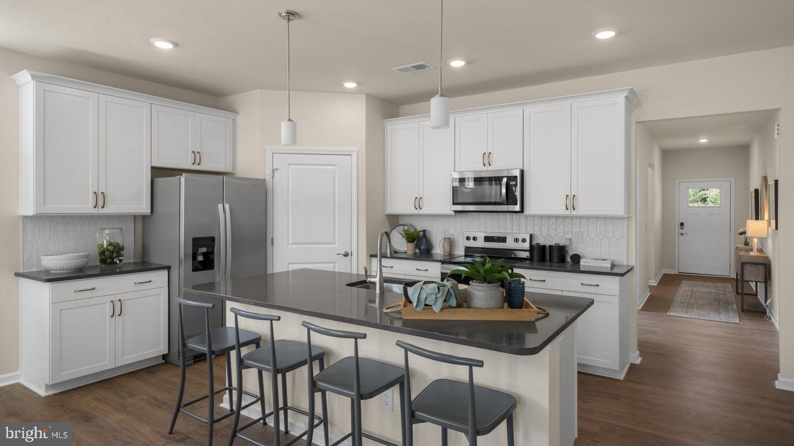 249 Hydrangea Way Winchester, VA 22602 - Photo 3 of 19 a kitchen with granite countertop a refrigerator a stove a sink and chairs