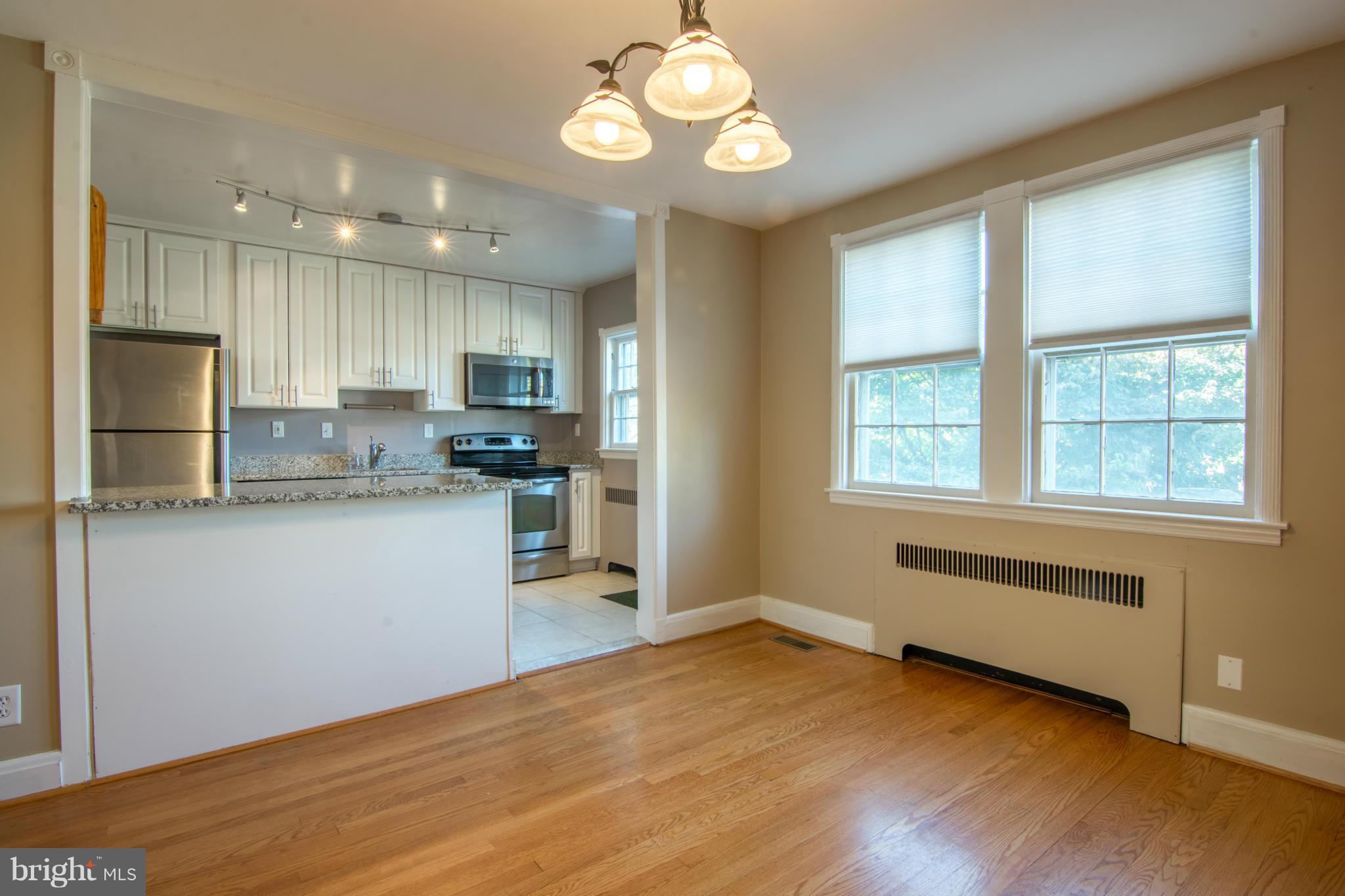 74 Murdock Road Baltimore, MD 21212 - Photo 12 of 30 a kitchen with kitchen island granite countertop wooden cabinets and refrigerator