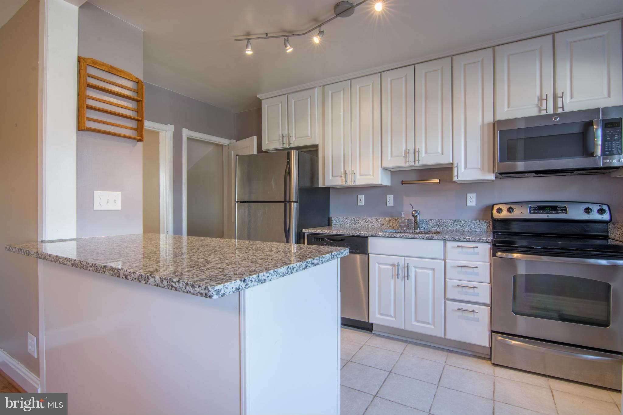 74 Murdock Road Baltimore, MD 21212 - Photo 13 of 30 a kitchen with stainless steel appliances granite countertop a stove a sink and a refrigerator