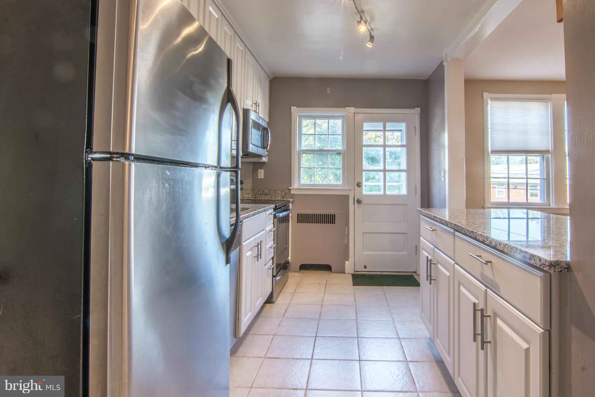 74 Murdock Road Baltimore, MD 21212 - Photo 14 of 30 a kitchen with a refrigerator a sink and dishwasher with a large window