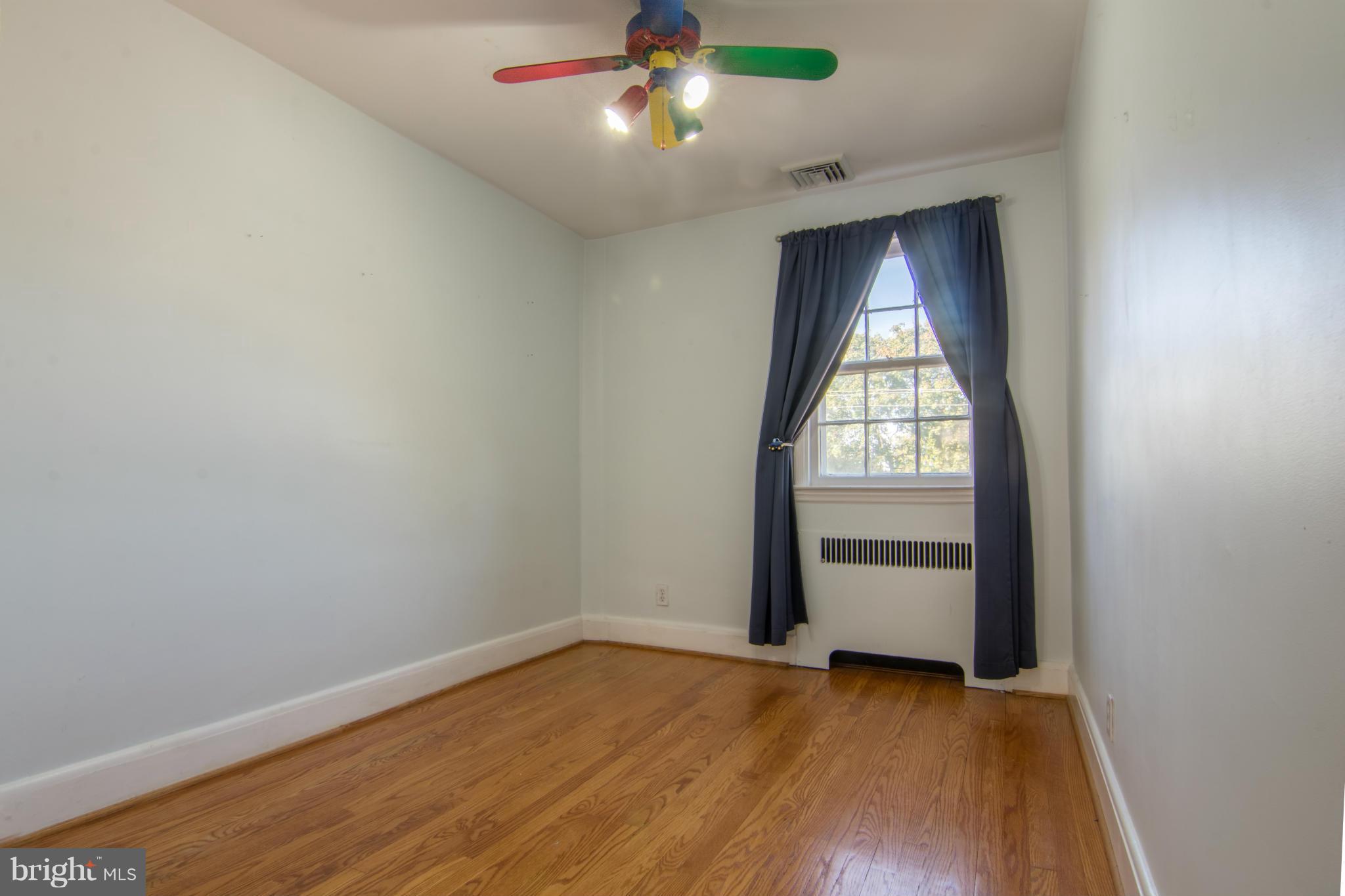 74 Murdock Road Baltimore, MD 21212 - Photo 19 of 30 an empty room with wooden floor cabinet and windows