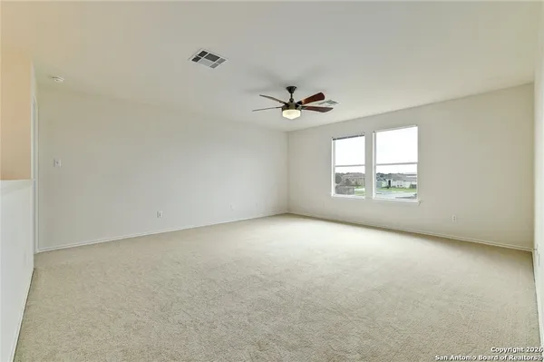 an empty room with a window and a ceiling fan