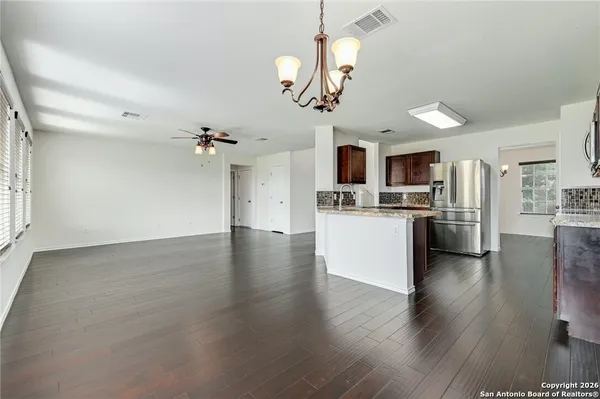 a view of a kitchen with a sink stainless steel appliances and wooden floor