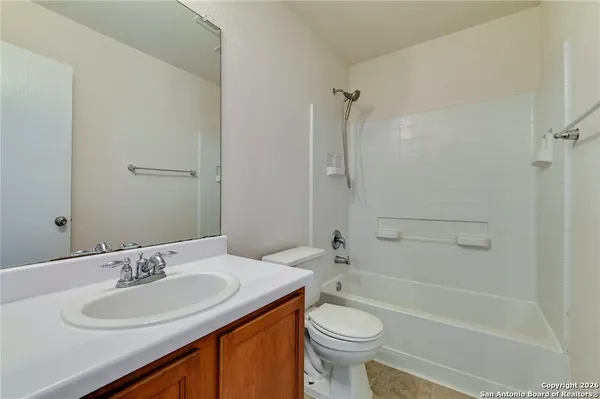 a bathroom with a granite countertop sink a toilet and shower
