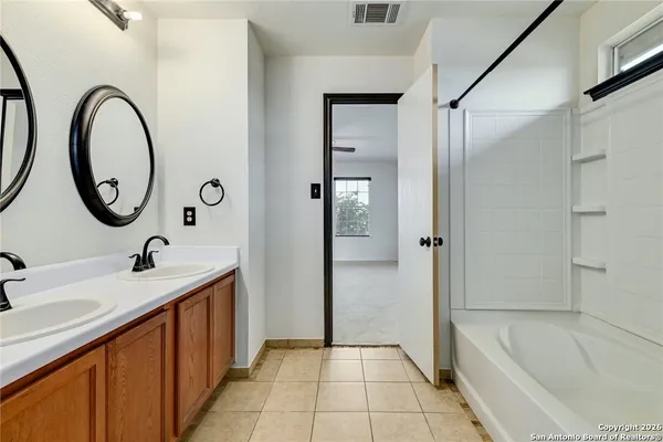 a bathroom with a tub sink and mirror