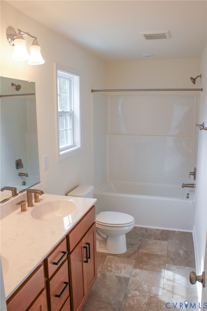 11632 Fort Cosby Drive Midlothian, VA 23112 - Photo 7 of 9 a bathroom with a sink a toilet a mirror and bathtub