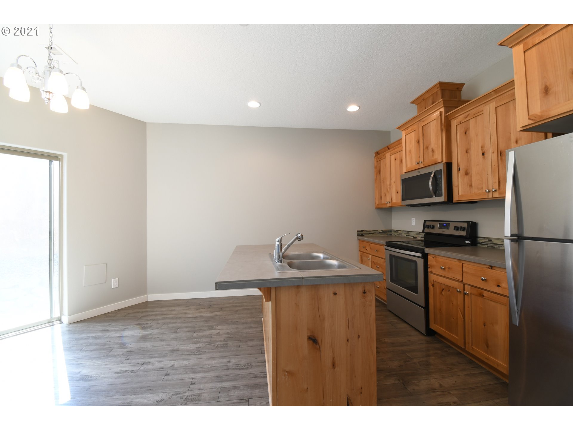 100 North 44th Place Ridgefield, WA 98642 - Photo 6 of 21 a kitchen with stainless steel appliances granite countertop a sink a stove a refrigerator a microwave oven with white cabinets