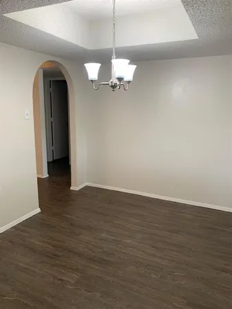 a view of a room with wooden floor and chandelier