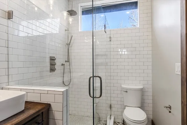 a bathroom with a granite countertop toilet sink and shower