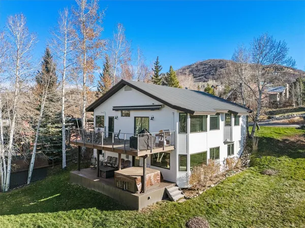 a view of a house with wooden deck front of house