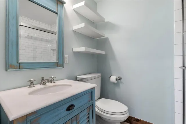 a bathroom with a sink toilet and a mirror