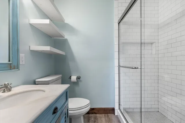 a bathroom with a granite countertop sink toilet and shower