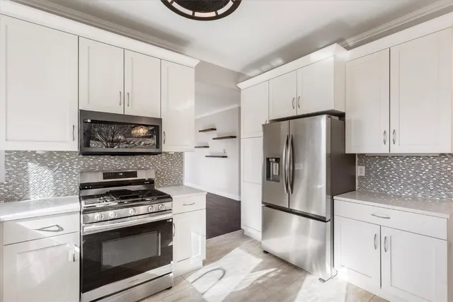 a kitchen with white cabinets and stainless steel appliances