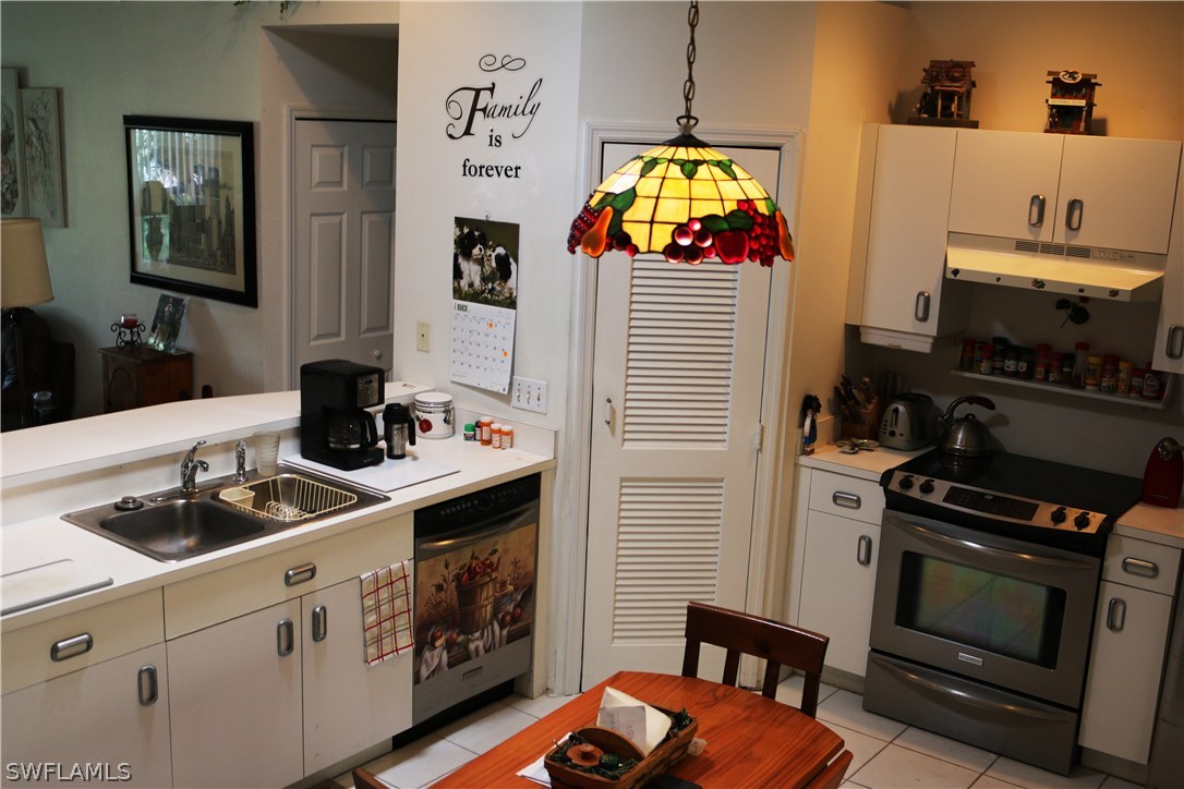 8288 Bahamas Road Fort Myers, FL 33967 - Photo 7 of 23 a kitchen with stainless steel appliances a stove a sink and cabinets