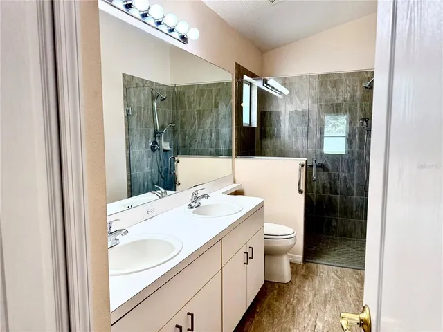 a bathroom with a sink a toilet and shower
