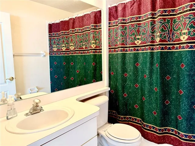 a bathroom with a sink a toilet and shower curtain
