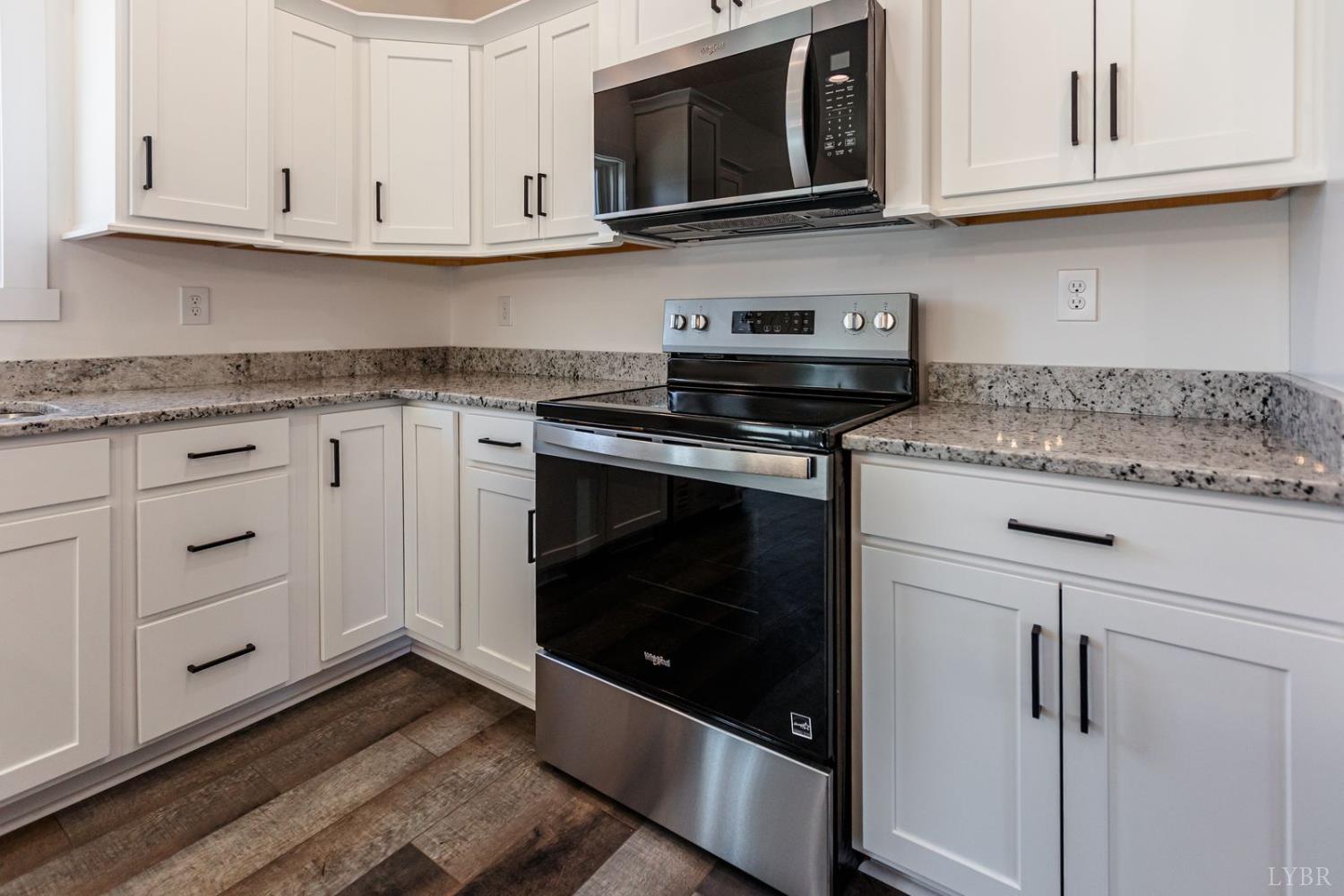 9740 Oakville Road Gladstone, VA 24553 - Photo 29 of 75 a kitchen with stainless steel appliances granite countertop white cabinets granite counter tops and a wooden floor