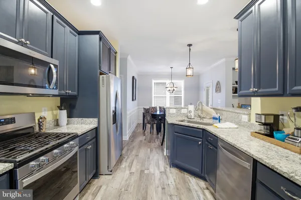 a kitchen with stainless steel appliances granite countertop a sink refrigerator and microwave