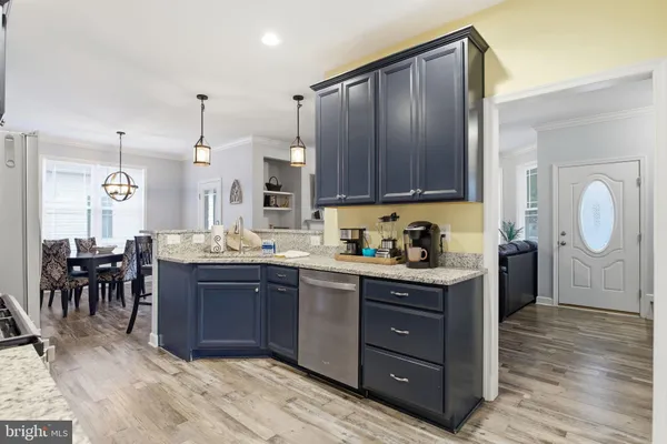 a kitchen with stainless steel appliances granite countertop a stove top oven a sink dishwasher a refrigerator and cabinets with wooden floor