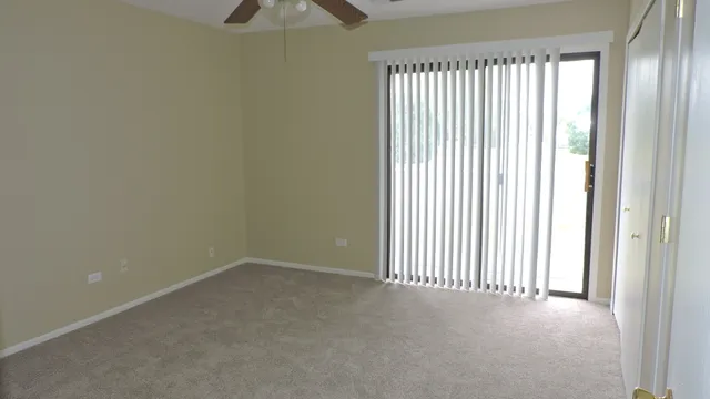 an empty room with a window and a ceiling fan