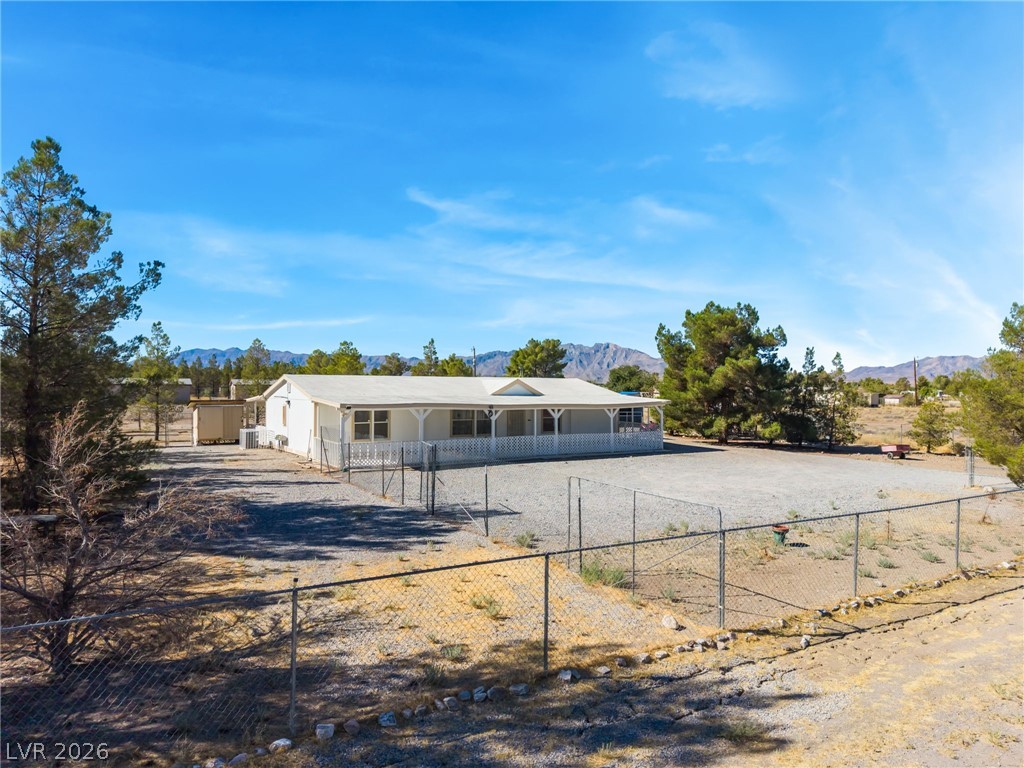 1551 West Wilson Road Pahrump, NV 89048 - Photo 47 of 68 An expansive fenced lot surrounds this single-level home set against a mountain backdrop.