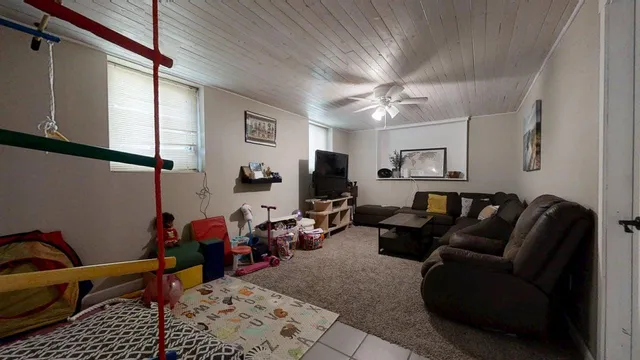 a living room with furniture a ceiling fan and a rug