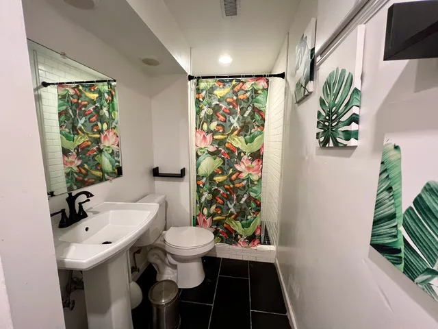 a bathroom with a sink a toilet and shower curtain