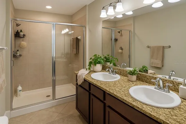 a bathroom with a granite countertop shower sink and mirror