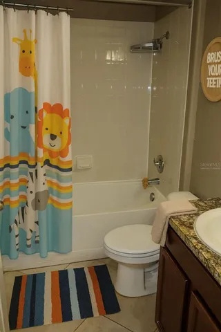 a bathroom with a granite countertop sink a toilet and shower
