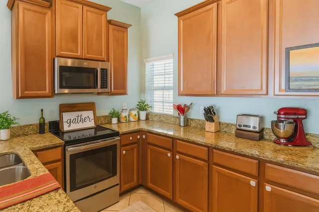a kitchen with stainless steel appliances granite countertop a stove a sink and a microwave