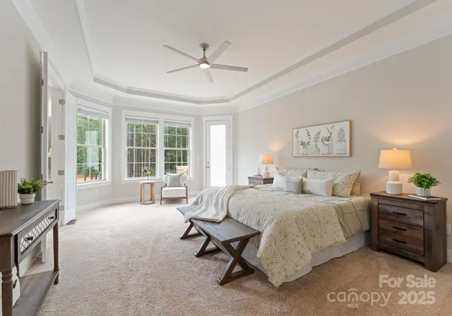 a bedroom with a bed a couch and large window