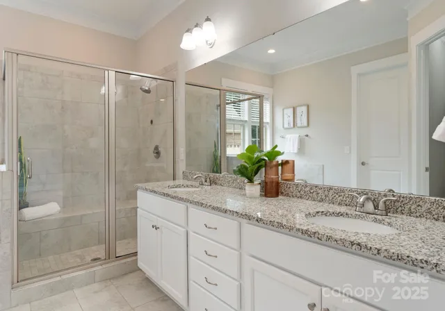 a bathroom with a granite countertop sink a shower and a mirror