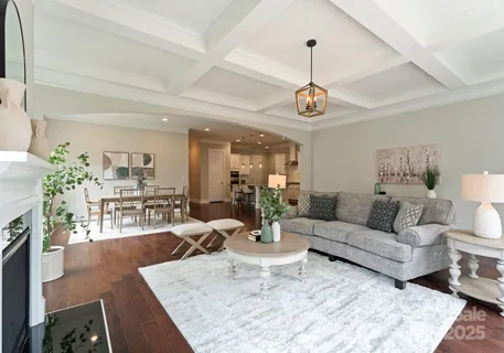 a living room with furniture dining table a window and potted plant