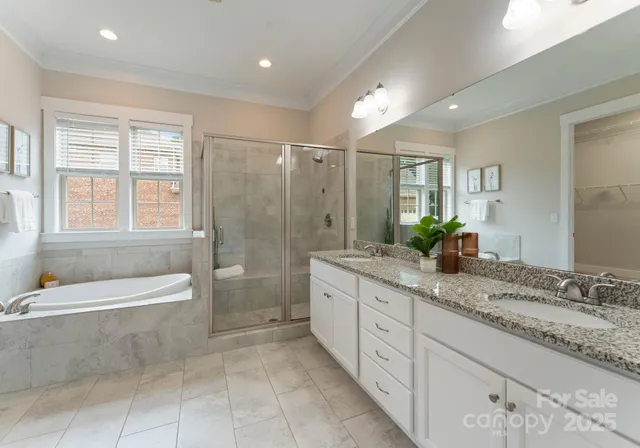 a spacious bathroom with a granite countertop tub sink a shower and a mirror