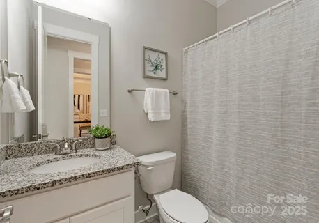 a bathroom with a granite countertop sink mirror vanity and toilet