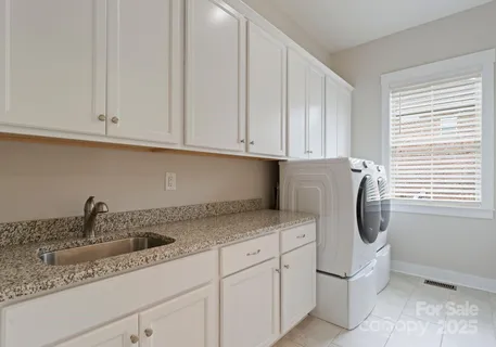 a kitchen with stainless steel appliances granite countertop white cabinets and sink