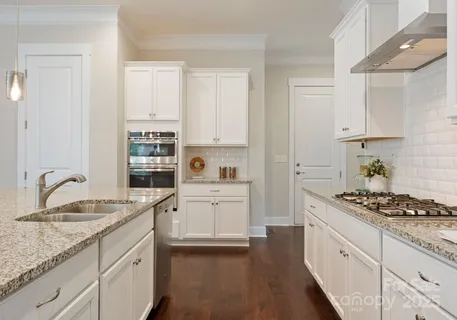 a kitchen with granite countertop a sink stove and cabinets
