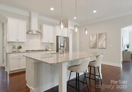 a kitchen with stainless steel appliances granite countertop a stove refrigerator sink and white cabinets