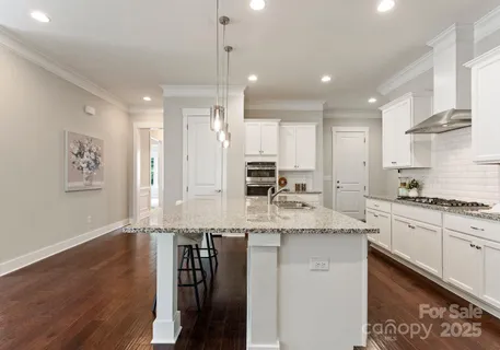 a large kitchen with stainless steel appliances granite countertop a stove a sink and a refrigerator